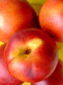 Close-up of ripe peaches in a yellow plastic basket