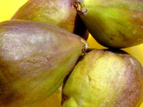 Four ripe figs in a yellow bowl