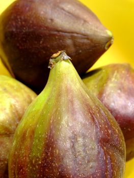 Four ripe figs in a yellow bowl