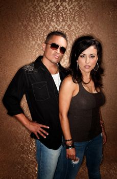 Attractive Hispanic Couple Posing in Front of Gold Background