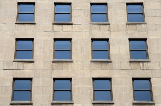 Blue windows of a modern stone building.
