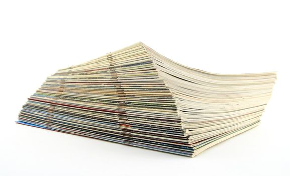 Stack of old magazines on white background.