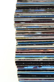 Closeup of stacked old magazines on white background.