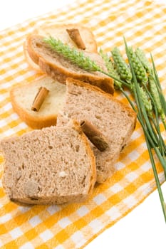 Bread and green wheat on table cover.