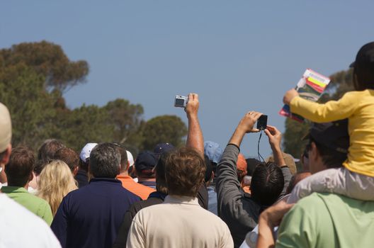 Fans huddle to get a glimpse of Tiger Woods warming up at the golf range.