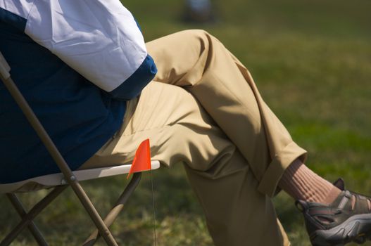 Golf Tournament Volunteer waits with ball flag marker.