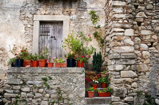 Old Sicilian stone house with flowers and vases