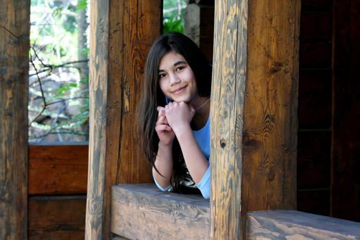 Beautiful young teen girl relaxing on porch, part asian, scandinavian background