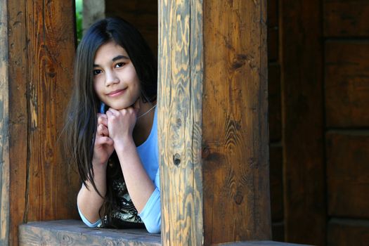 Beautiful young teen girl relaxing on porch, part asian, scandinavian background