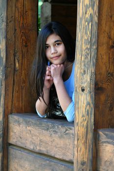 Beautiful young teen girl relaxing on porch, part asian, scandinavian background