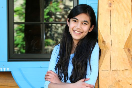 Beautiful young teen girl relaxing on porch, part asian, scandinavian background