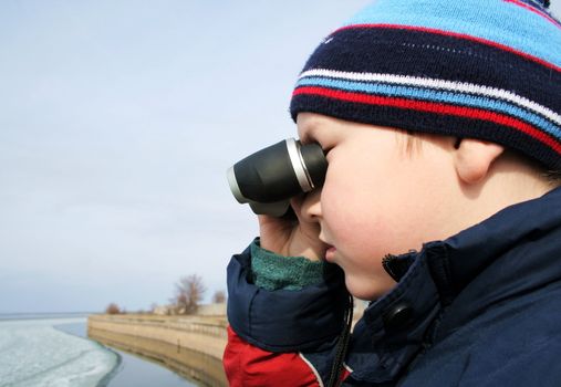 Little boy with binoculars at a sea