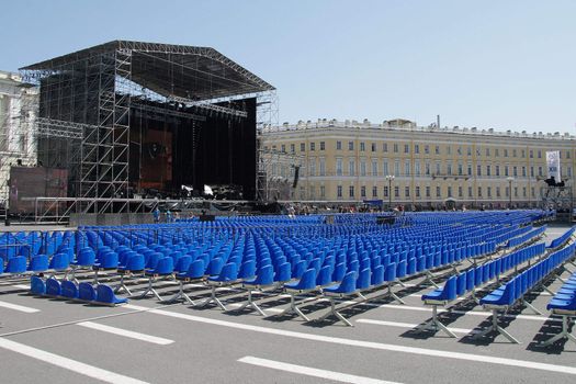 Rows of empty blue plastic chairs before the concert