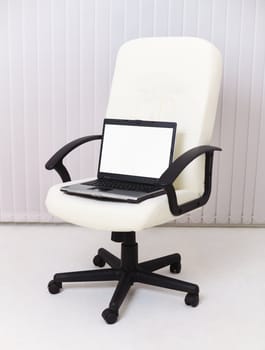 Laptop sits in a leather chair for the manager