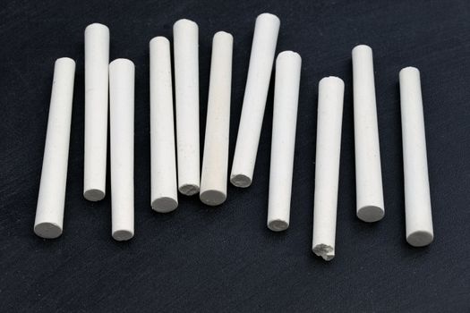 several white chalk sticks on blackboard background