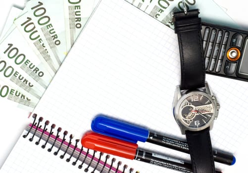 euro bills, two pens, watch, notebook, cellular phone