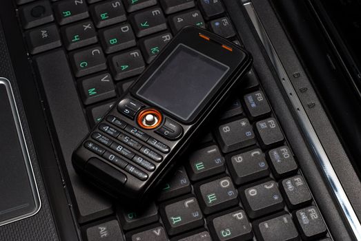 Cellular phone on a laptop