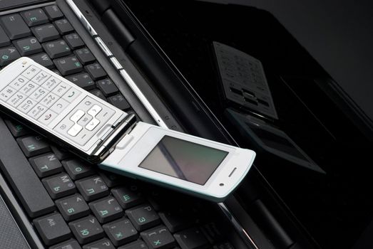 Cellular phone on a laptop