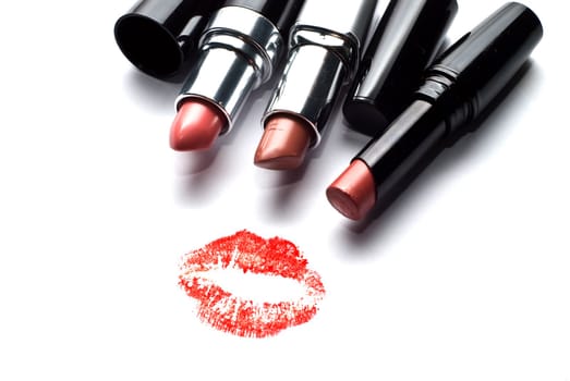 three lipsticks and a kiss on a white background