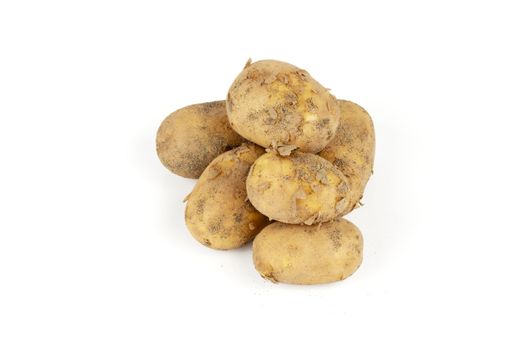 Small pile of brown unpeeled potatoes on a reflective white background