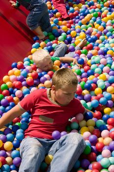 Two boys playing in playground colourful ball pool