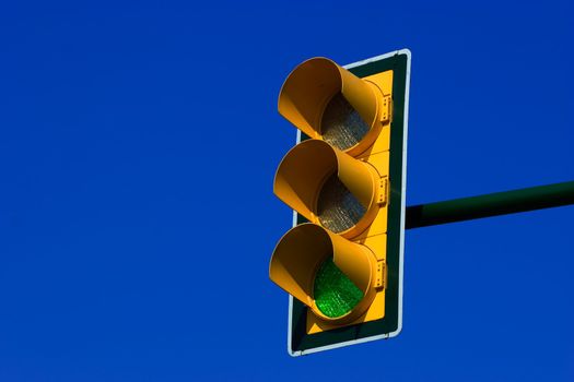 Green traffic light on blue sky