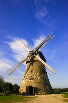 Traditional Old dutch windmill in Latvia against blue sky with white clouds