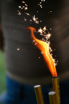 Burning birthday cake sparkler. Flame with branching white sparks.