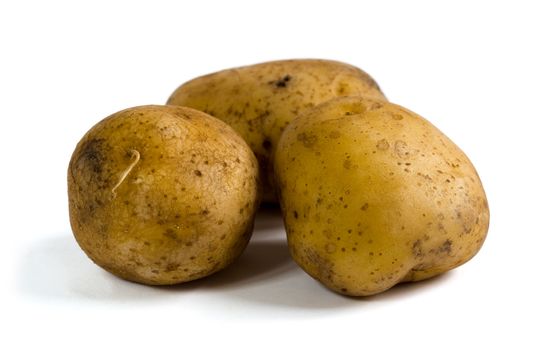 Three raw potatoes on white background with shadows. Clipping path included