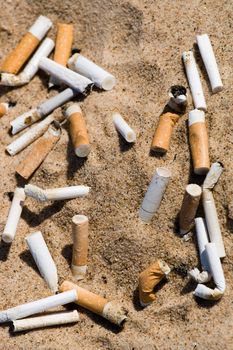 Cigarette butt in sand. Litter on the beach