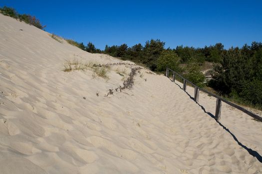 Wooden fence in sand dunes. Curonian Spit is on the UNESCO's World Heritage List in Lithuania