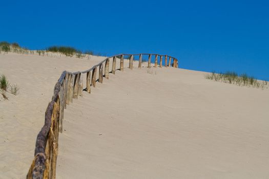 Wooden fence in sand dunes. Curonian Spit is on the UNESCO's World Heritage List in Lithuania