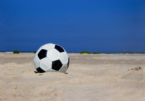 Soccer ball on sandy beach after game