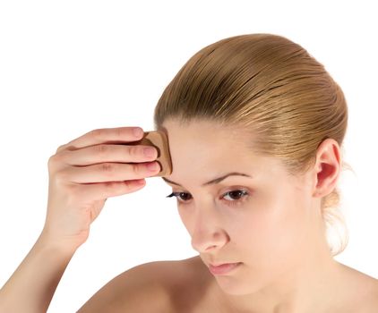 young woman putting make up on her face. Isolated