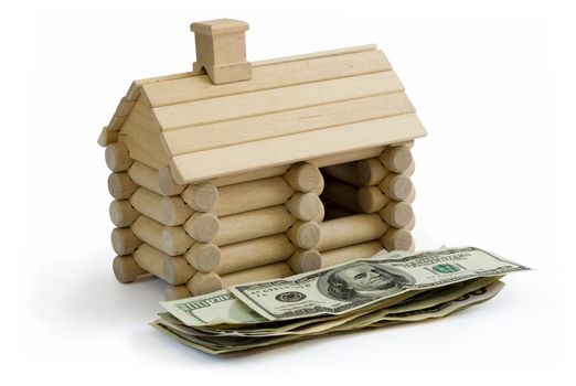 Miniature Log House building model and money dollar bills in foreground. Clipping path included to remove object shadow or replace background.