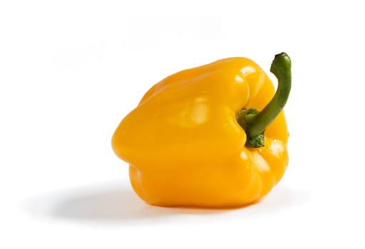 Isolated sweet yellow bell pepper (Capsicum annuum) with shadow on white background. Clipping path included.