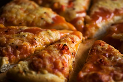 Pieces of cheese pizza on wooden plate