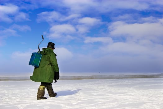 Ice Fisherman going away. Ice fishing - very popular winter hobby in Estonia, Latvia, Lithuania, Russia etc.