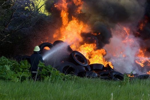 Firefighters battle with burning tires