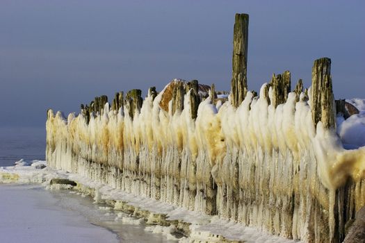 Ice-covered breakwater and icicles like line of white bearded gnomes