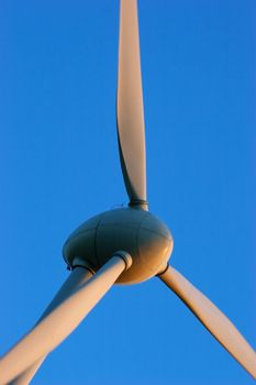 Windturbines close-up on blue sky. Producing environment friendly energy to prevent global warming.