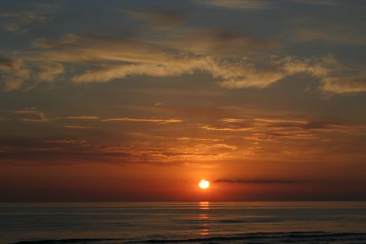 Sunset skies with clouds over sea