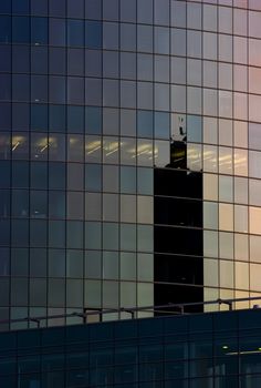 Corporate office building facade and reflection of other skyscraper in late evening