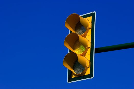 Yellow traffic light on blue sky