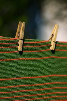 Red and green striped carpet pegged to a clothesline. Place for copy text