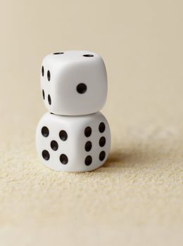Two dice on the yellow sand - still life