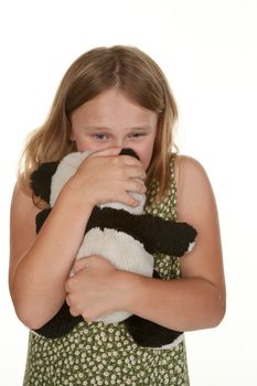 young girl is upset and gives her bear a cuddle