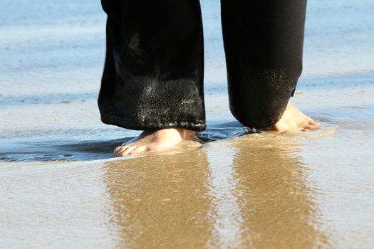 Woman standing in water, focus on her feet