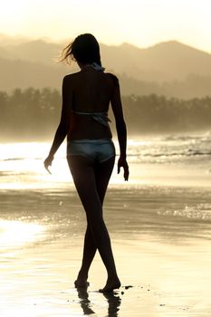 woman's silhouette on the beach by sunset