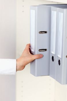 Hand clerk takes the shelf archival documents